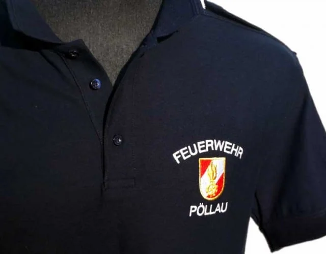 Dunkelblaues Polo mit gesticktem Wappen der Feuerwehr Pöllau