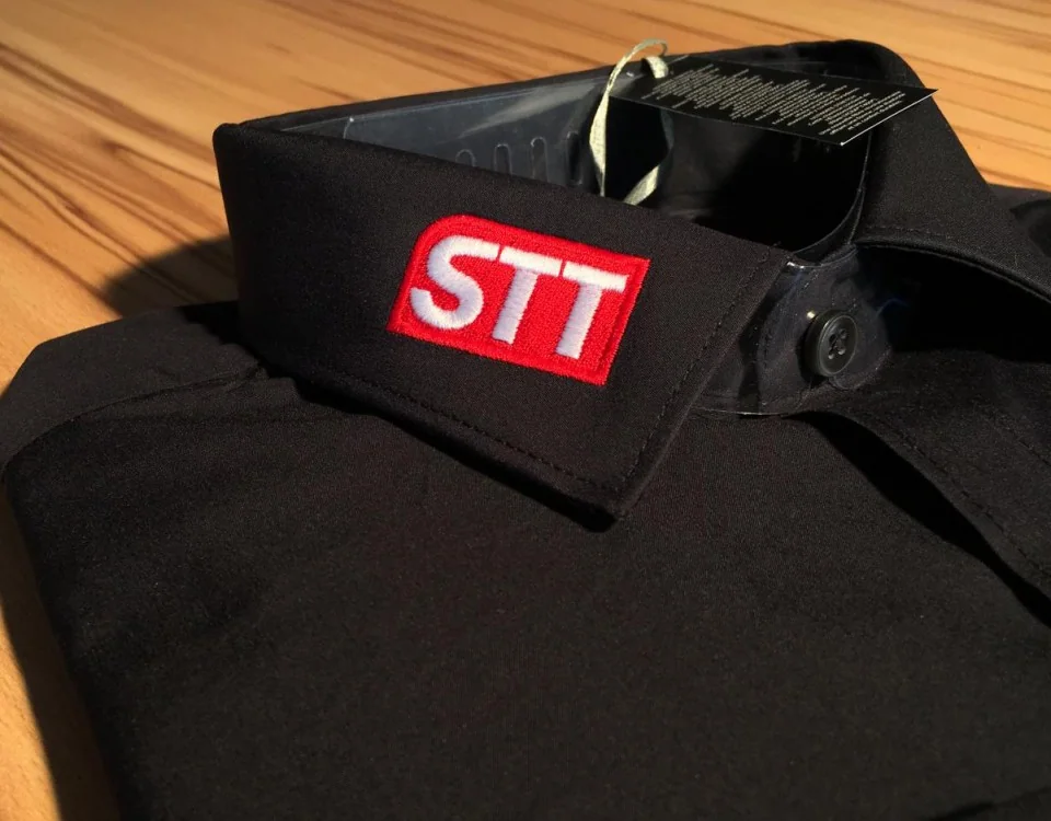 Schwarzes Firmenhemd mit gesticktem Logo am Kragen