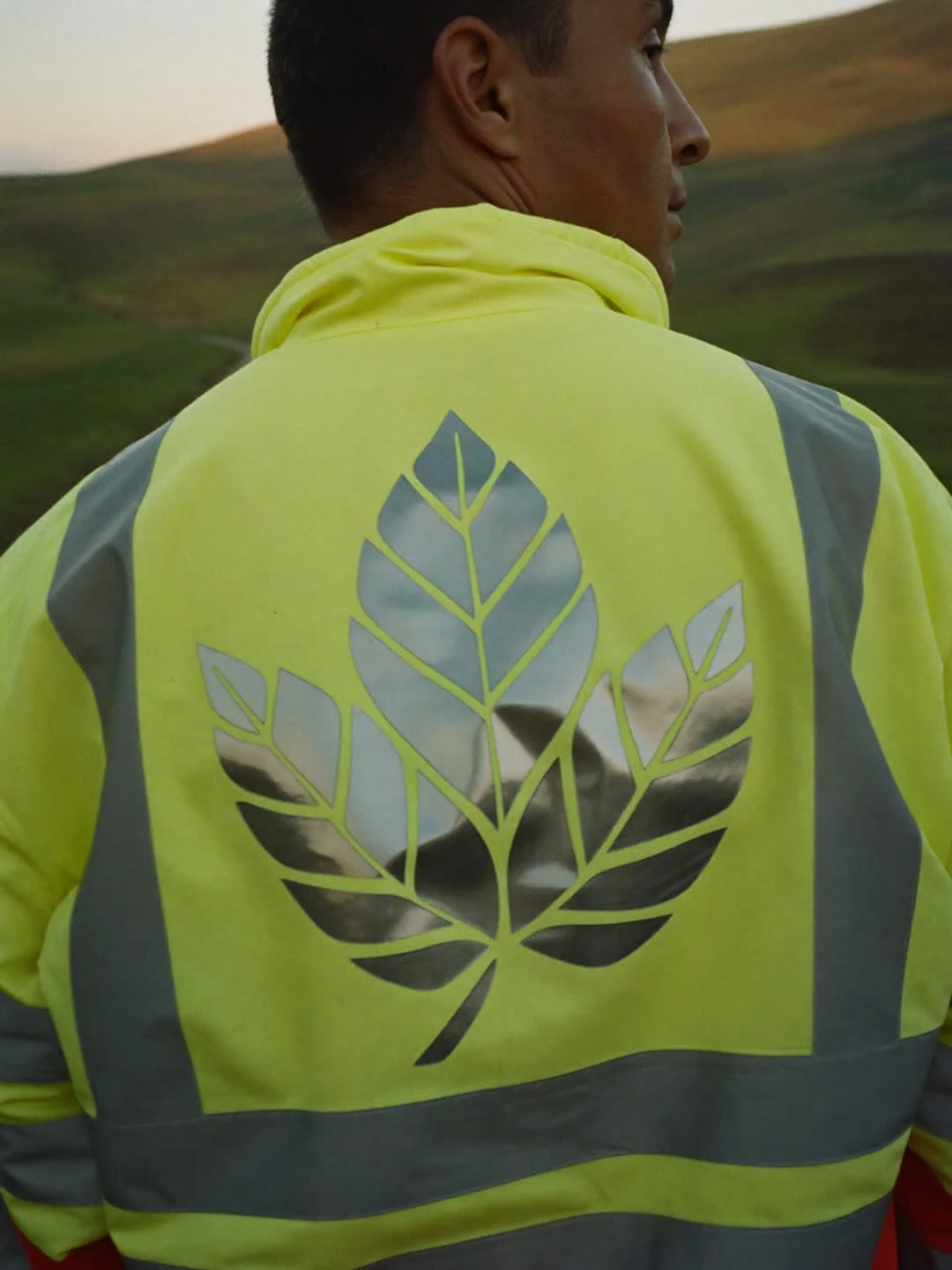 Straßenarbeiter in Warnschutzjacke mit großem reflektierendem Emblem am Rücken